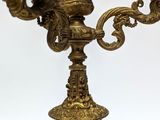 a gold colored candle holder with two candles on it
