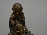 bronze statue of a child sitting on top of a book