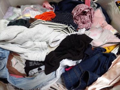 un gros tas de vêtements dans un panier posé par terre