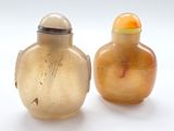 deux vases posés l'un à côté de l'autre sur une surface blanche