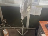 a desk with a fan and a computer on it