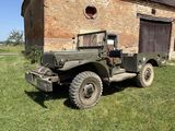 un vieux camion militaire garé devant un bâtiment en briques