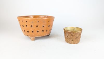 two small bowls and a small cup on a white surface