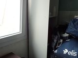 an image of a room with a bed and a refrigerator