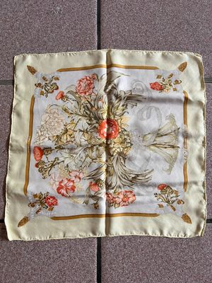 un foulard carré orné d'un motif représentant un oiseau et des fleurs