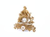 une horloge en or posée sur une table blanche