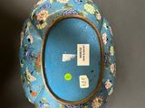 a blue vase with flowers on it sitting on a table