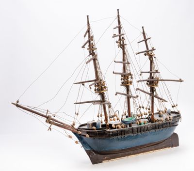 a small model of a ship on a white surface