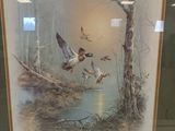 framed picture of ducks flying over a pond in a wooded area