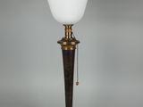 une lampe en laiton plaqué, dotée d'un abat-jour en verre blanc et posée sur un socle en bois