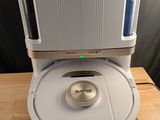 le robot est posé sur la table, à côté de l'aspirateur