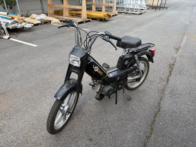 une moto noire garée sur un parking à côté d'un immeuble