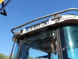 a close up of a tractor with a crane in the background