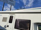 a white rv parked next to a sign on the side of the road