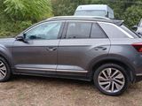 the grey volkswagen suv is parked in a lot with other cars