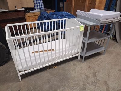 un lit de bébé et un lit dans une chambre où il y a beaucoup de meubles