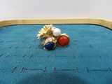 an image of a pair of earrings sitting on top of a blue surface