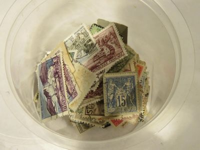un bol en verre rempli de timbres-poste posé sur une table