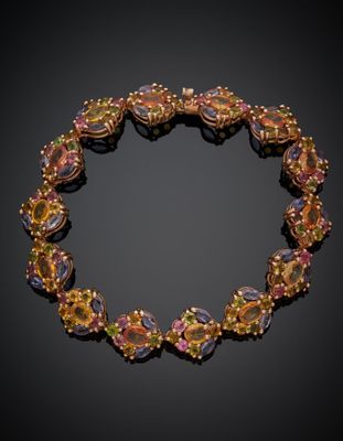 un gros plan d'un bracelet orné de pierres colorées sur fond noir