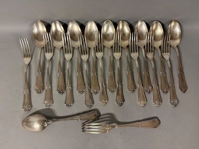 a lot of silver spoons and forks laid out on a table