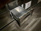 a silver oven that is open and sitting on a wooden floor