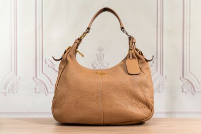un sac à main marron posé sur une table en bois