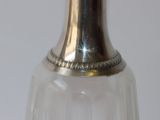 a glass vase with a silver top on a table