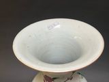 a small white vase with a floral design on it