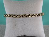 un bracelet plaqué or orné d'un motif tressé