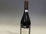 a bottle of wine sitting on top of a table next to a bottle of wine