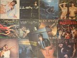 many different album covers on the wall of a room