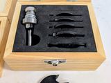 a wooden box with tools in it on a white surface