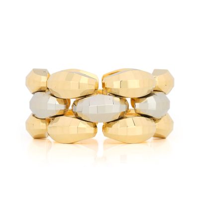 a close up of a gold and silver bracelet on a white surface