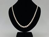 un collier de perles blanches sur un mannequin noir