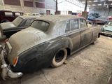an old car is parked in a garage next to other cars