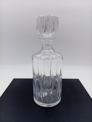 un gros plan d'une bouteille en verre transparent posée sur une surface noire