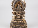 une statue en or représentant un Bouddha assis sur une fleur de lotus