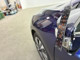 a close up of a blue car with a measuring tape on it