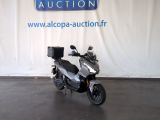 un scooter garé devant un panneau