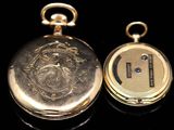 a gold pocket watch sitting next to another gold pocket watch