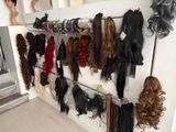 de nombreux types de perruques accrochés au mur