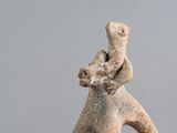 une figurine représentant un homme portant un bébé sur le dos