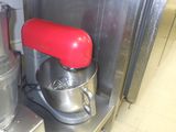 un mixeur rouge posé sur un plan de travail en inox