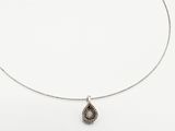 un gros plan d'un collier avec un pendentif en forme de larme suspendu à une chaîne