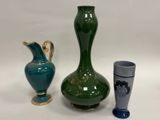 trois vases et un verre posés sur une table