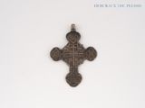 an old silver cross on a white surface with a white background
