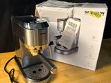 une cafetière posée sur une table à côté d'une boîte