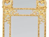 un miroir en or richement décoré sur lequel figure un oiseau