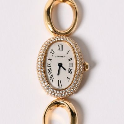an image of a gold watch with a diamond bezeled face