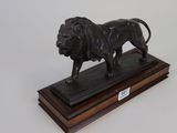 statue of a lion on a wooden base on a white background